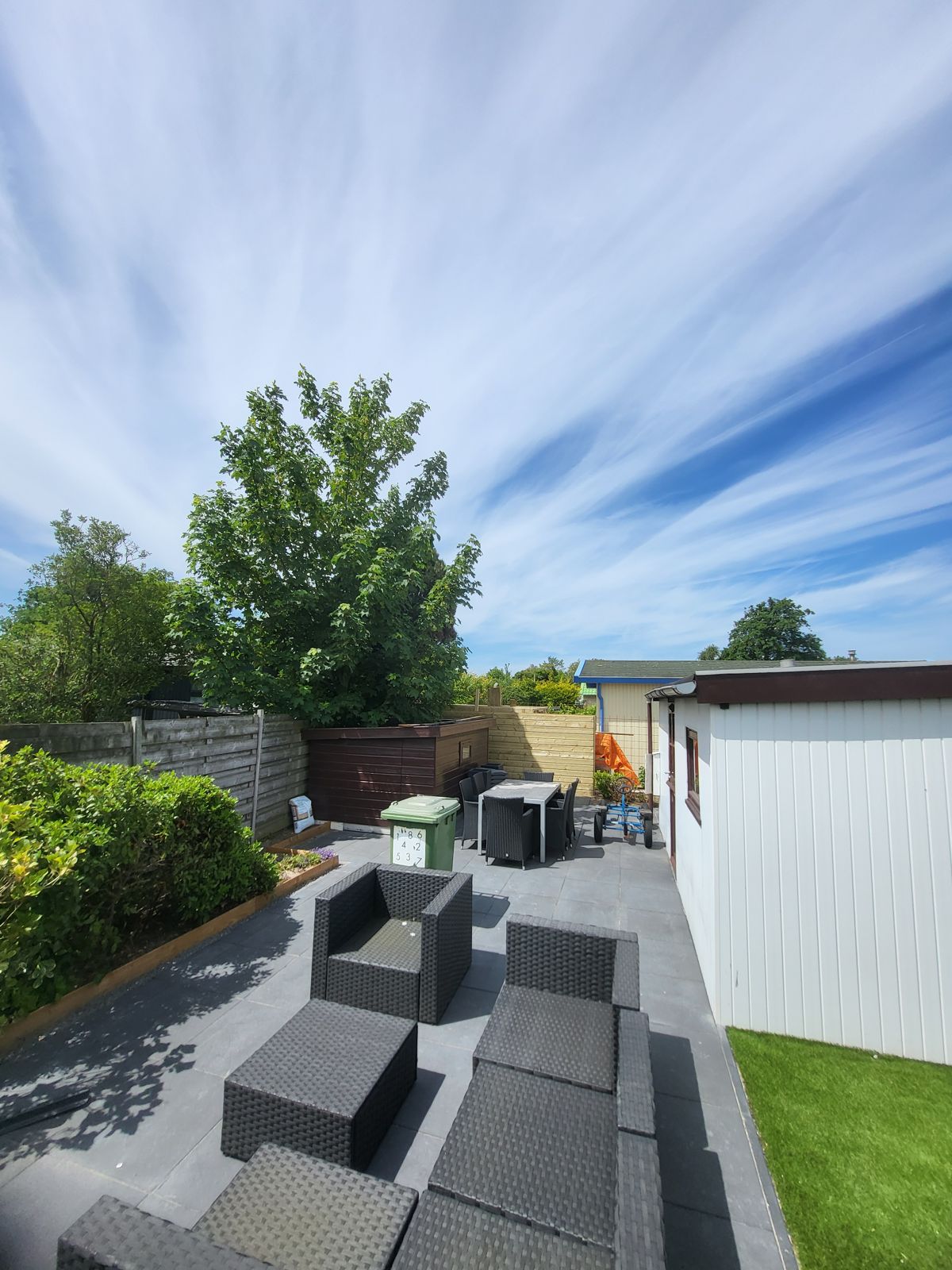 Afgewerkte tuin met terras, loungeset en gazon