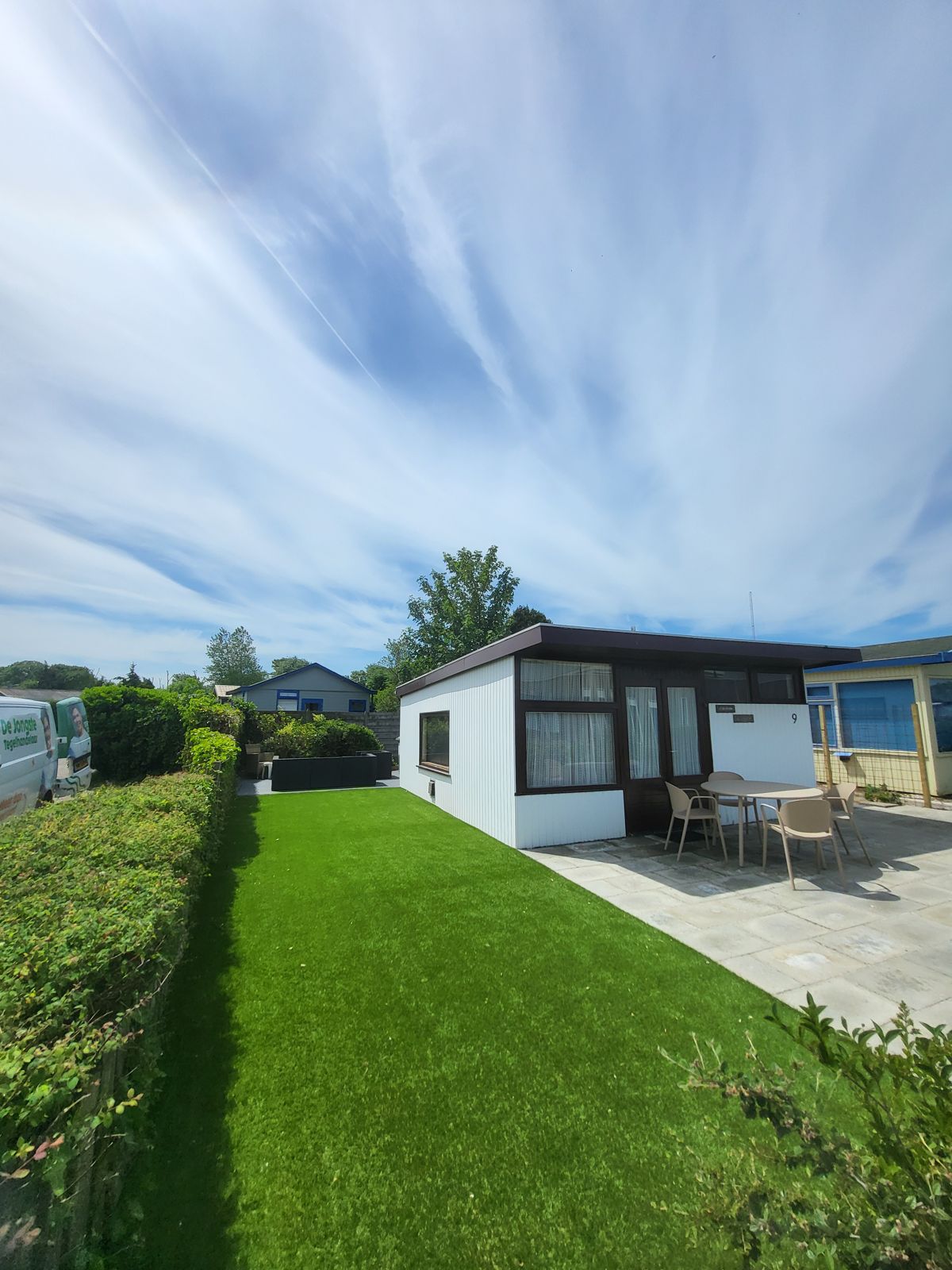 Strak aangelegde tuin met gazon en terras bij een chalet